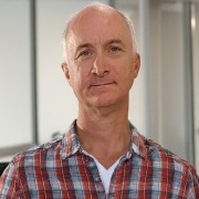 Balding man with a wryly serious expression